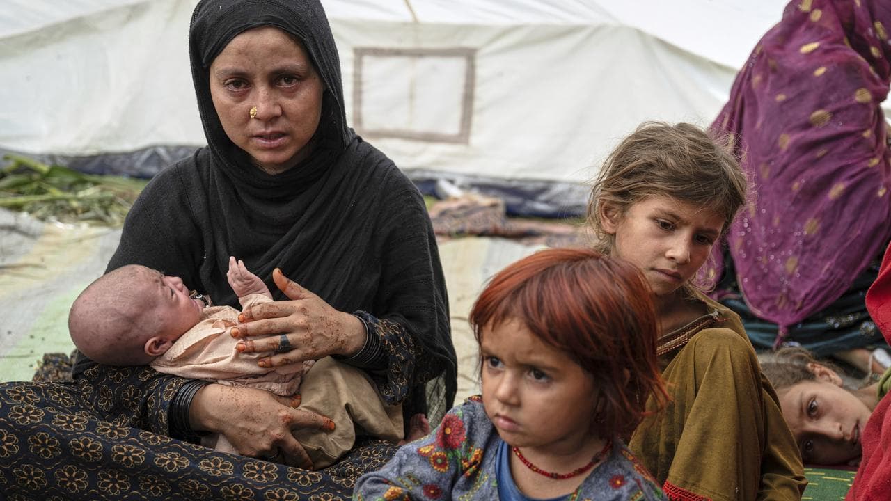 Woman and children wait for earthquake assistance in Afghanistan