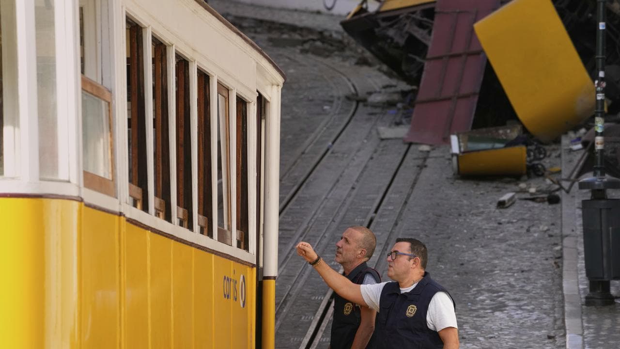 Police inspect the site where a streetcar crashed in Lisbon