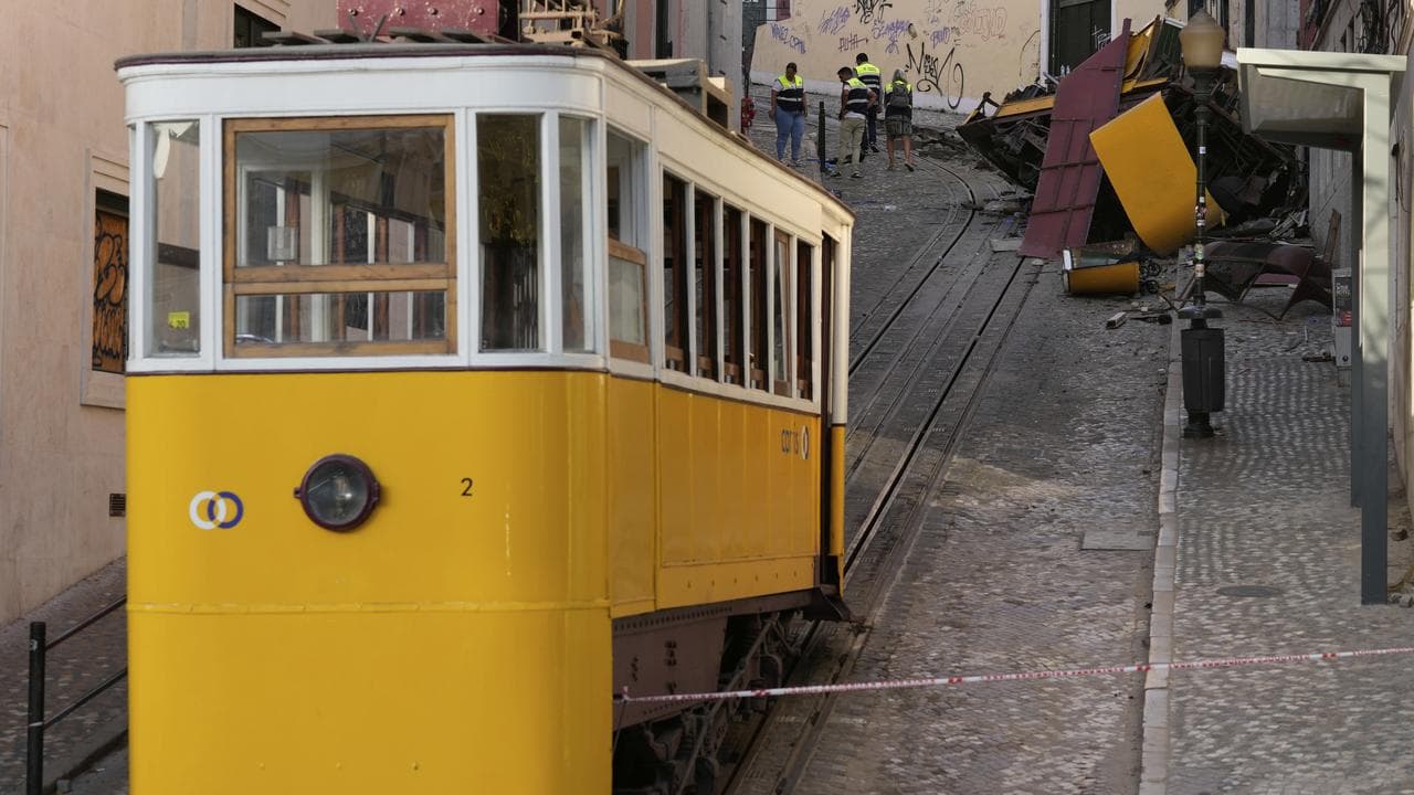 Police inspect where a streetcar crashed in Lisbon, Portugal