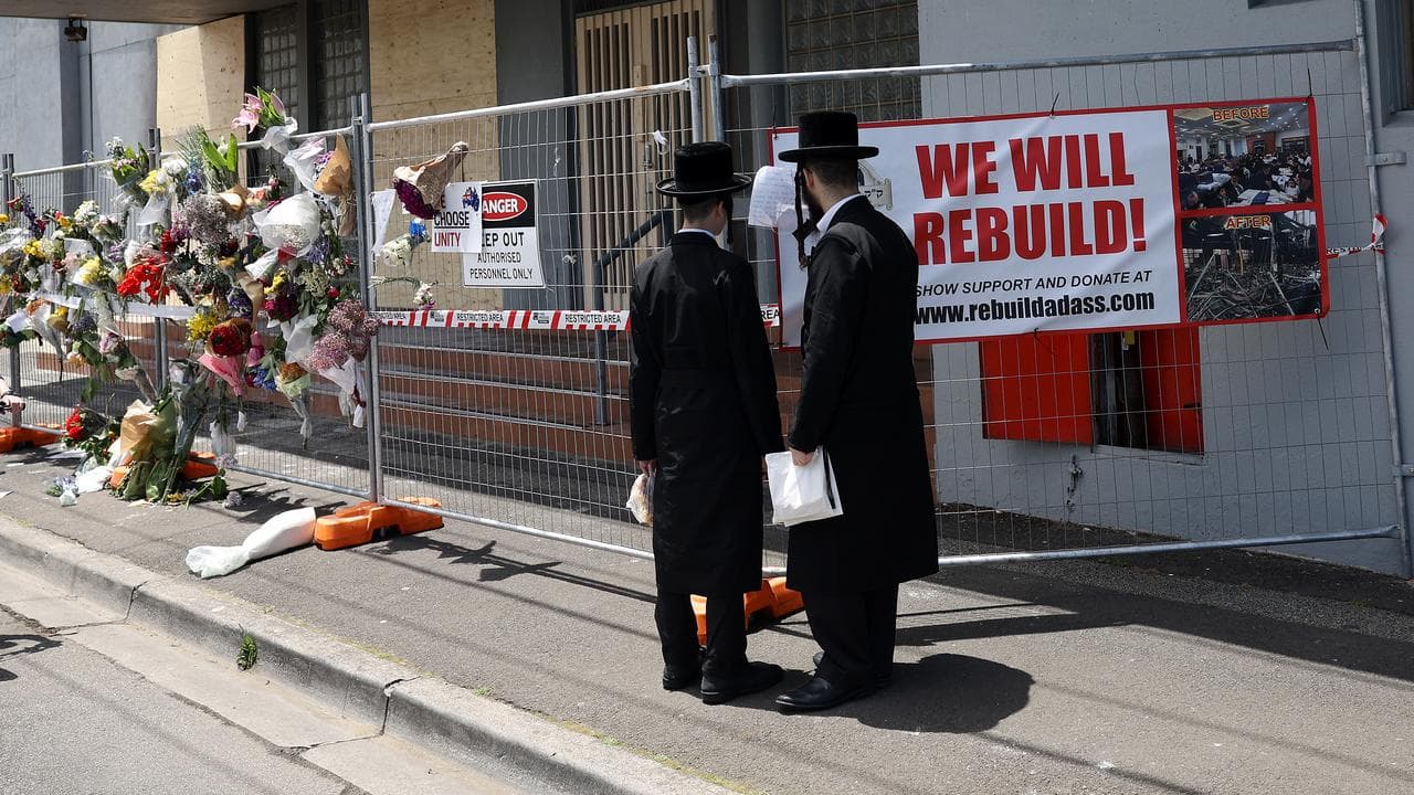People gather outside the Adass Israel Synagogue after a firebombing