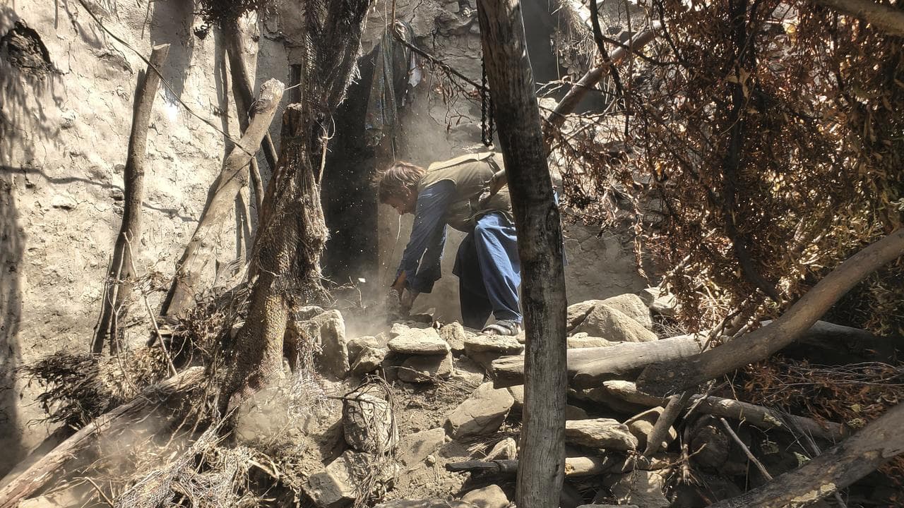 Man clears rubble of a house after an earthquake in Afghanistan
