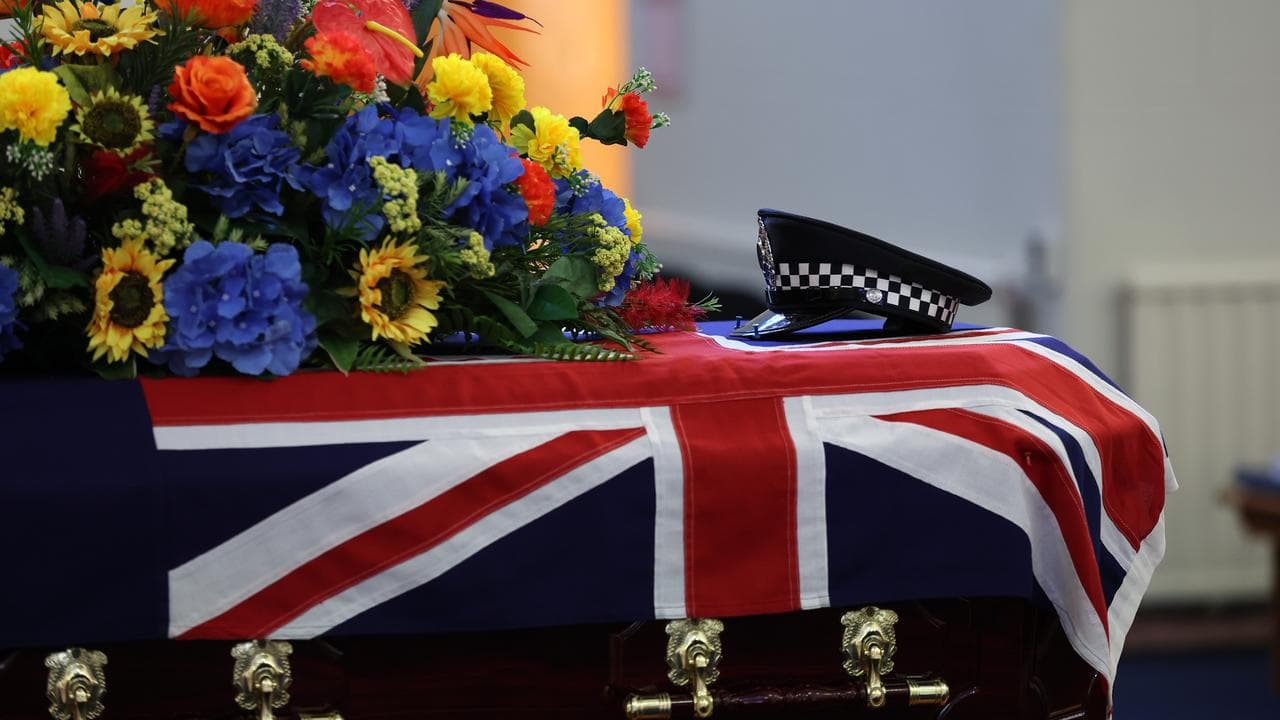 Officer Vadim De Waart-Hottart 's police hat on top of his casket