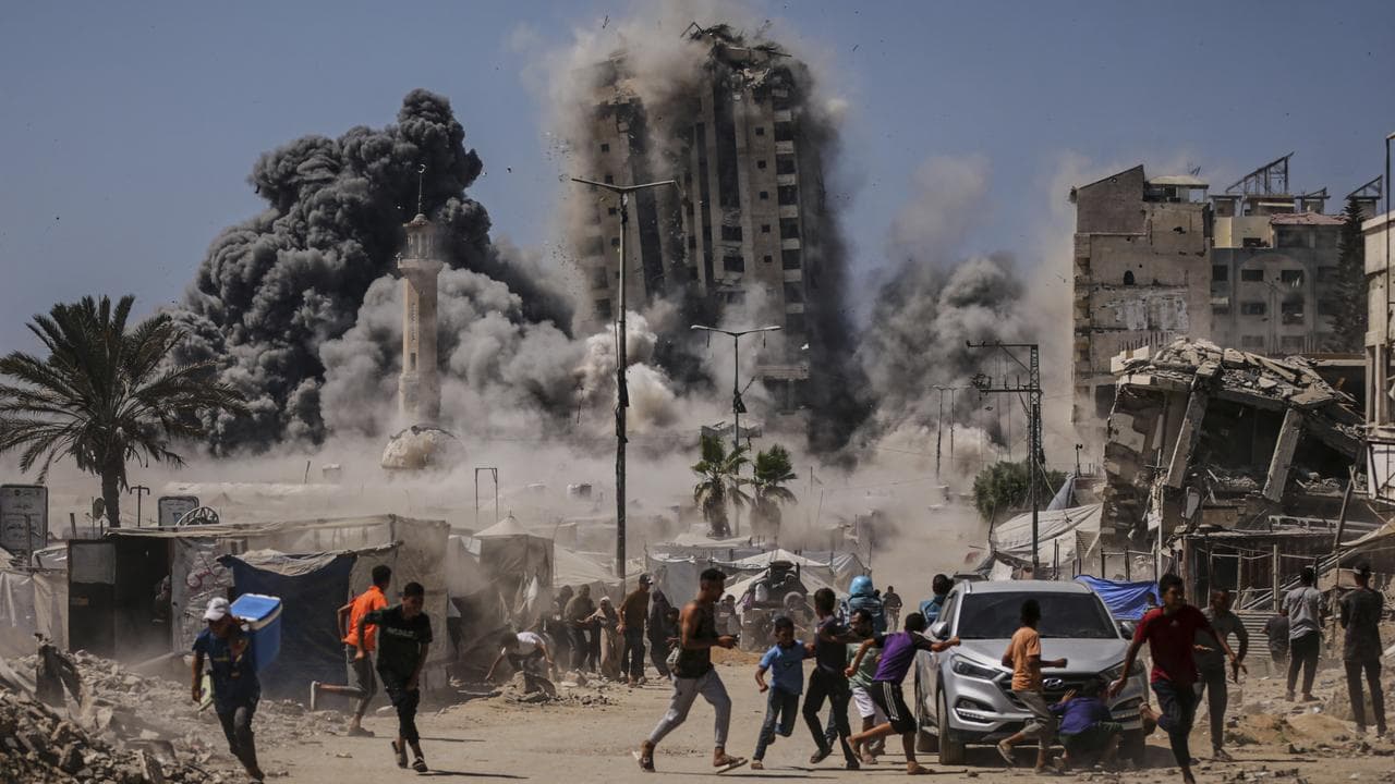 Palestinians run for cover during an Israeli air strike in Gaza City