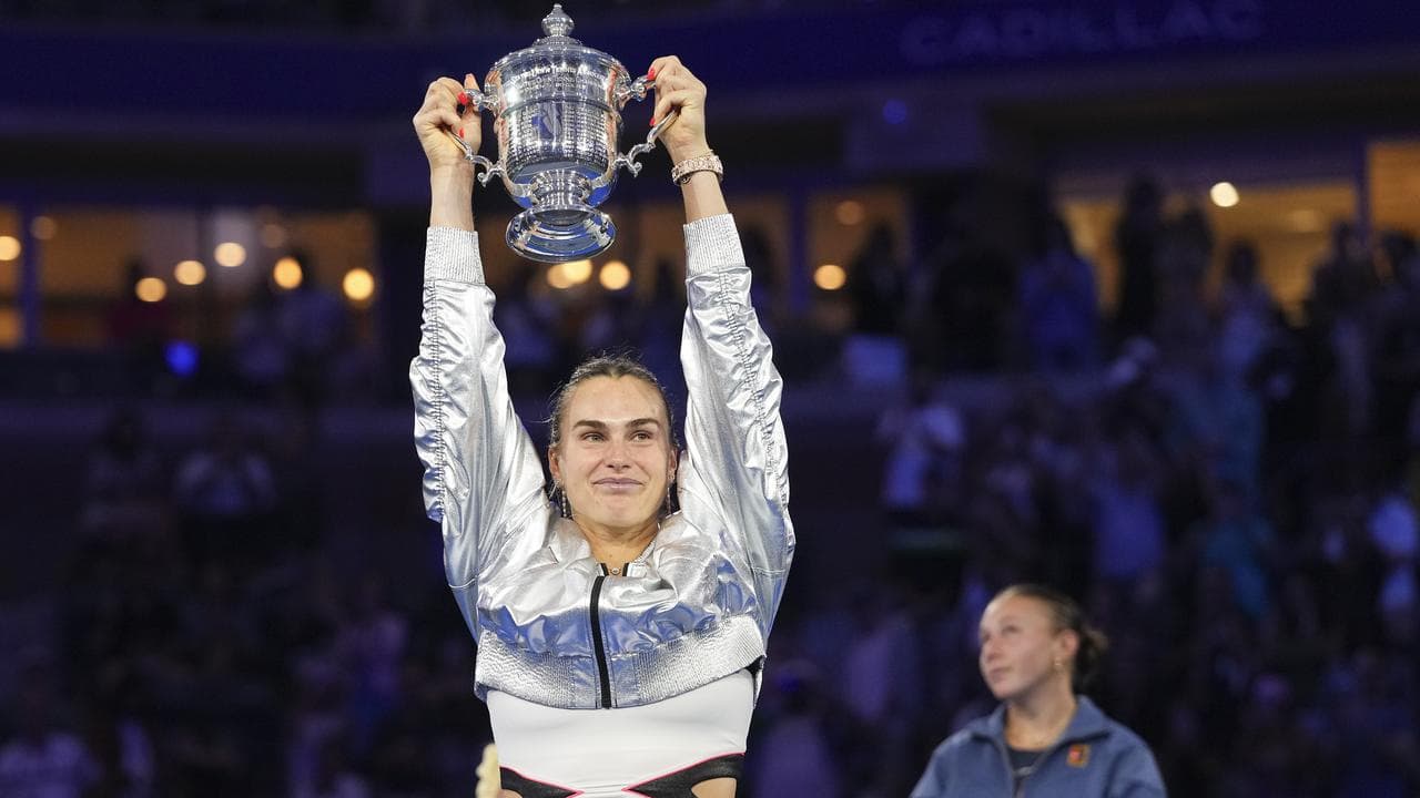 Aryna Sabalenka raises the championship trophy.