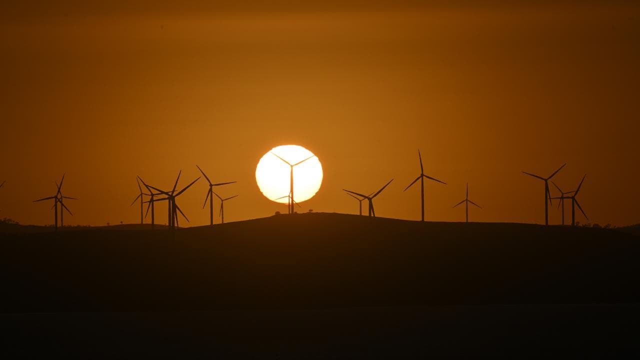 Sun rises over wind turbines at the Capital Wind Farm, ACT
