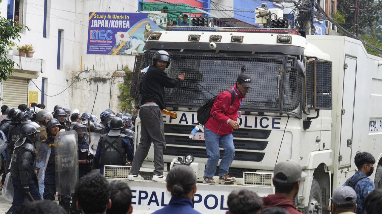 Protesters block an armoured vehicle in Kathmandu, Nepal