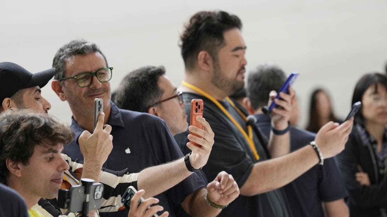 Attendees take a closer look at the iPhone 17 Pro