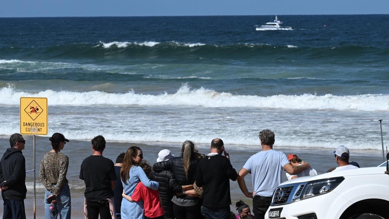 Family and friends gather at the scene of a fatal shark attack.