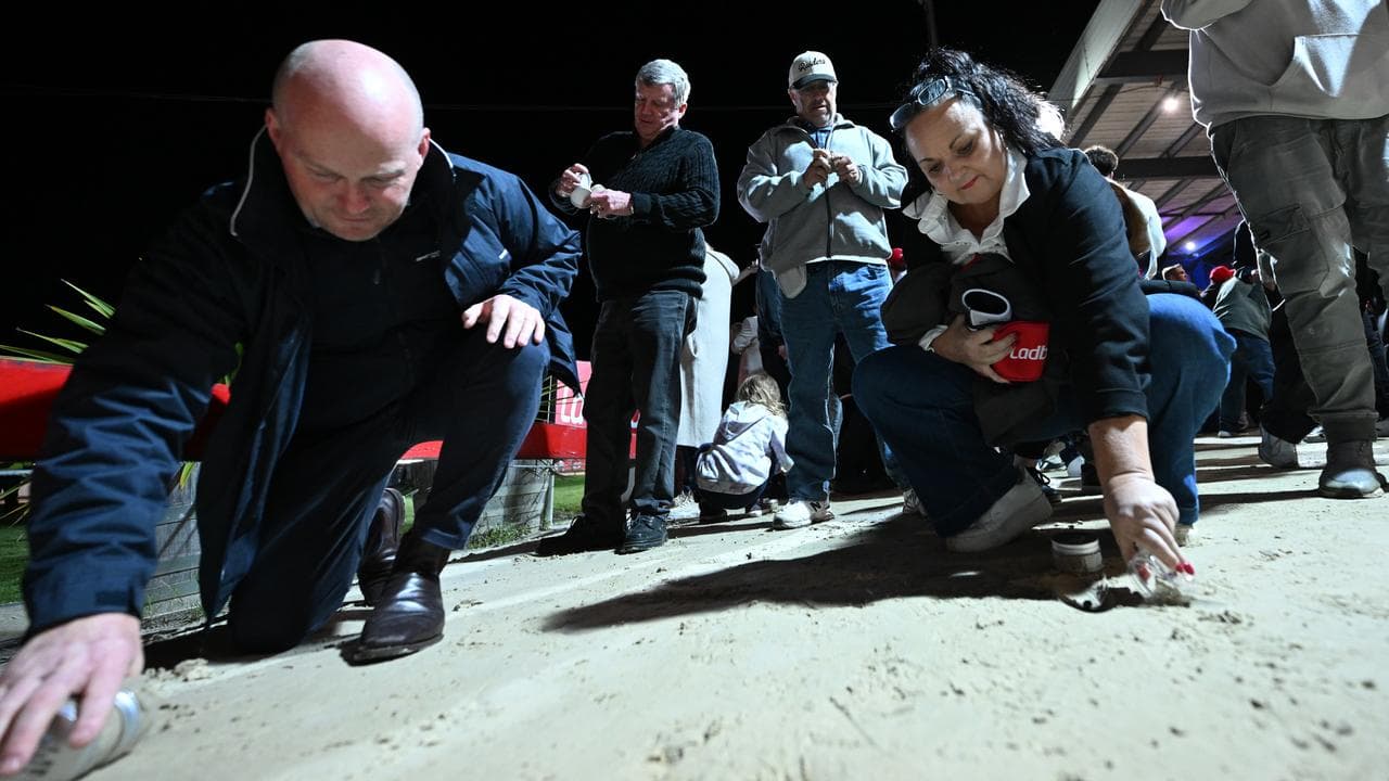 Punters pour on to the track to collect jars of sand.