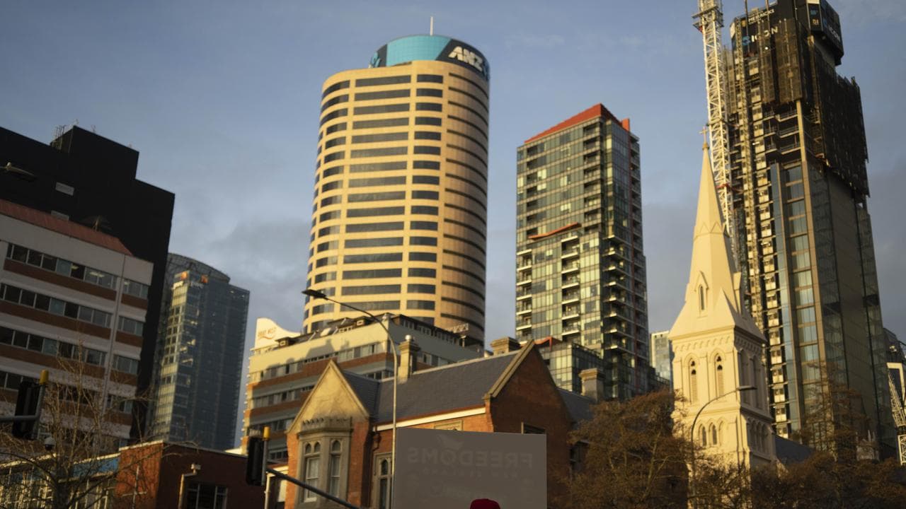 A man holds a banner in a street in Auckland,