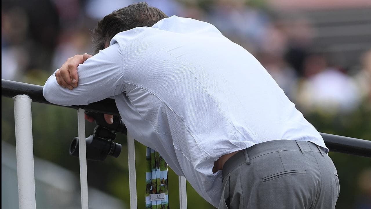 A man hunched over at a race track