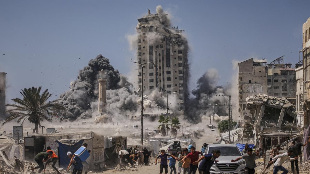 Palestinians flee during an Israeli air strike in Gaza City