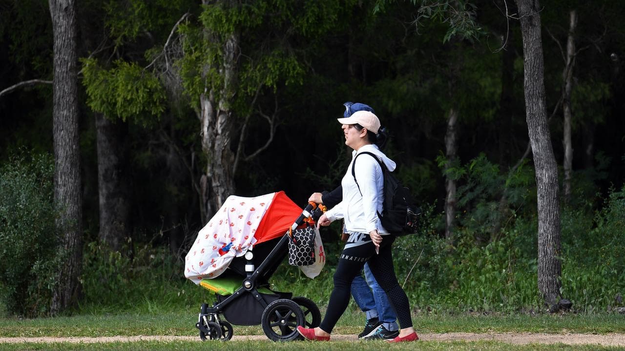 A young family walk through a park