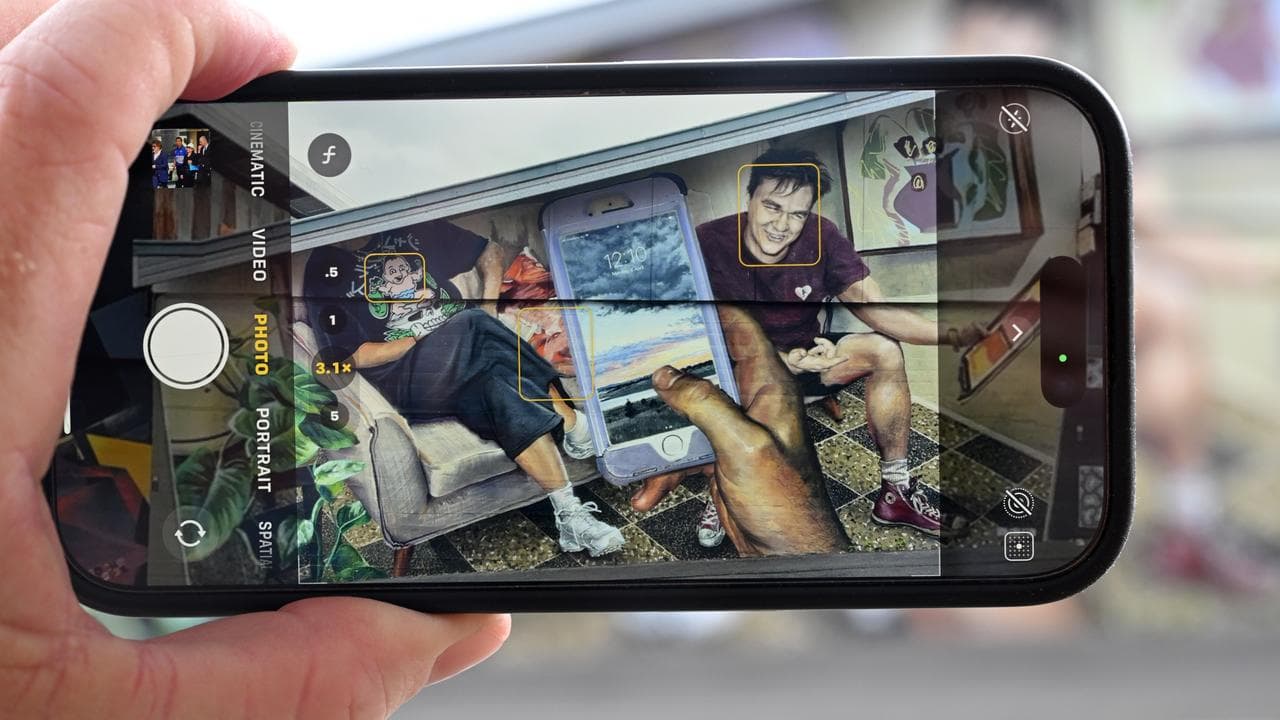 An iPhone is seen taking a picture of a mural