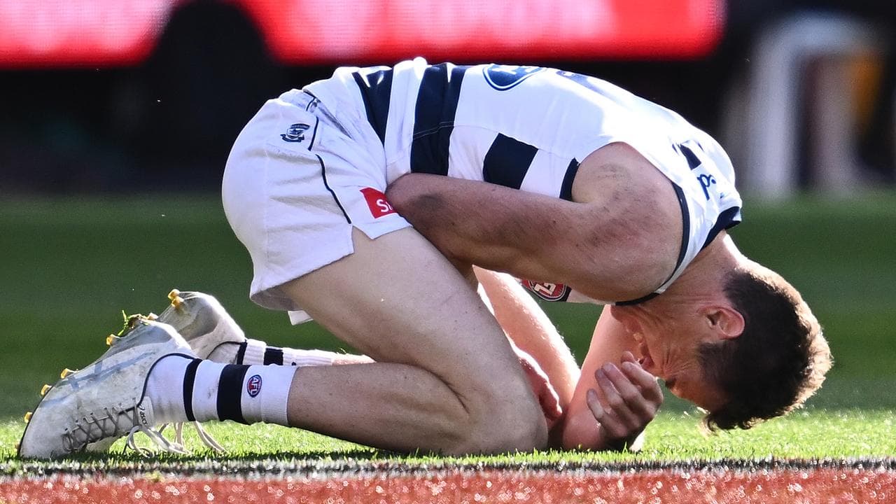 Geelong forward Jeremy Cameron clutches his injured forearm.
