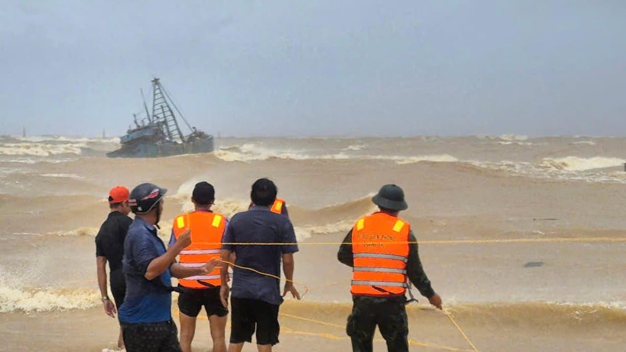 People work to rescue fishermen on a boat due in Quang Tri