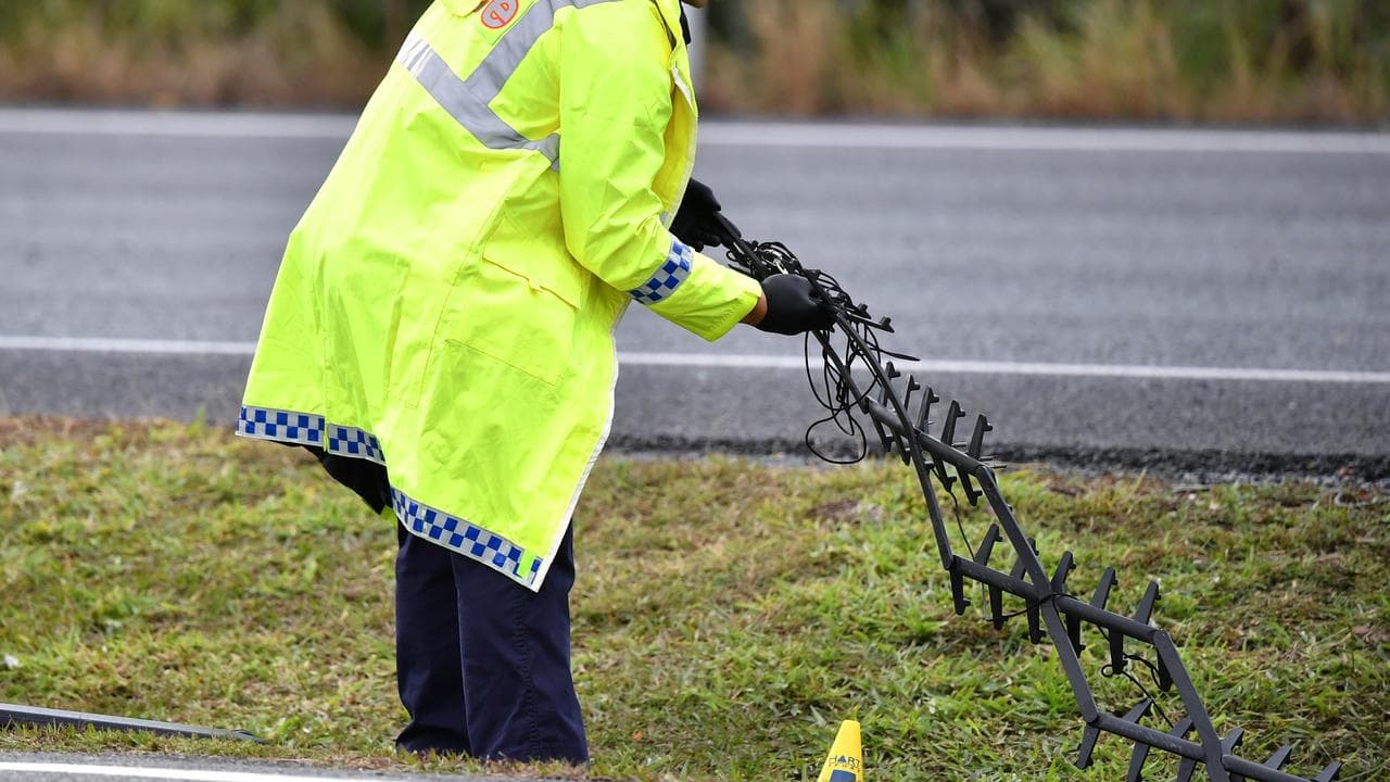 Police officer carries road spikes (file)