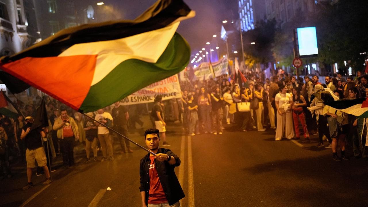 A demonstrator waves a Palestinian flag at a protest in Madrid, Spain