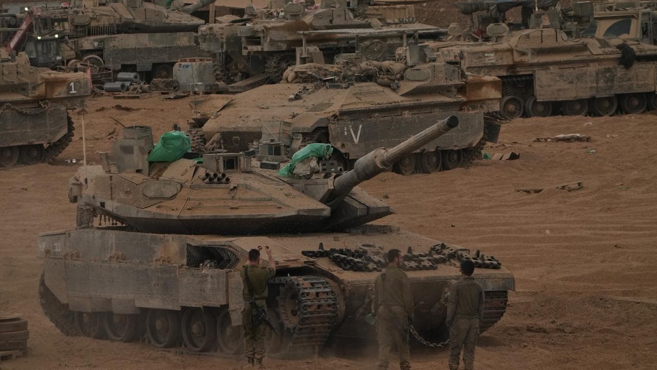 Israeli soldiers work on a tank near the Israeli-Gaza border