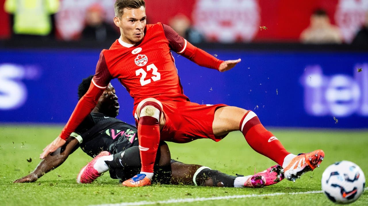 Nestory Irankunda (left) shoots past Canada's Niko Sigur.