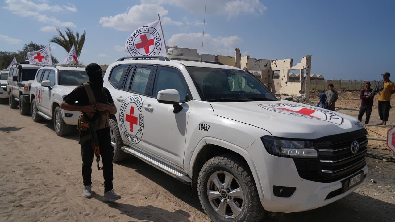 Hamas gunman next to Red Cross vehicles carrying Israeli hostages