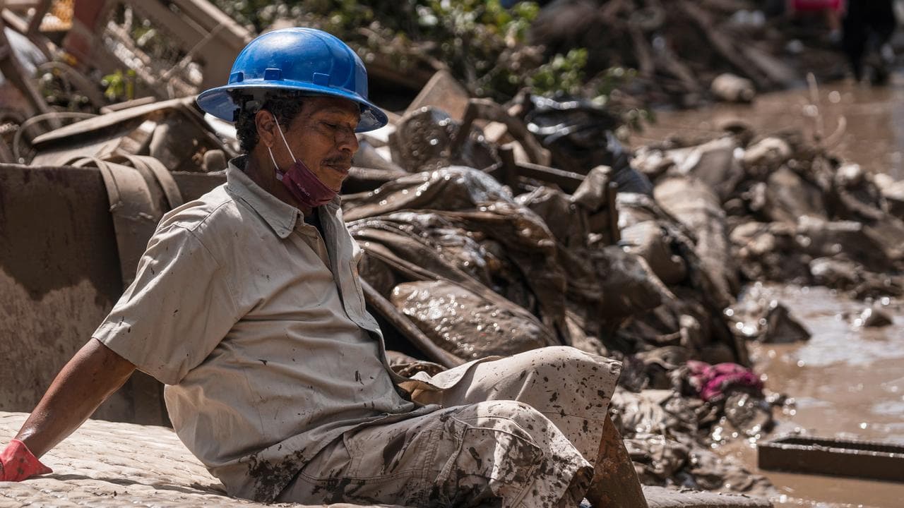 A man who cleaning flooded homes takes a break in Poza Rica