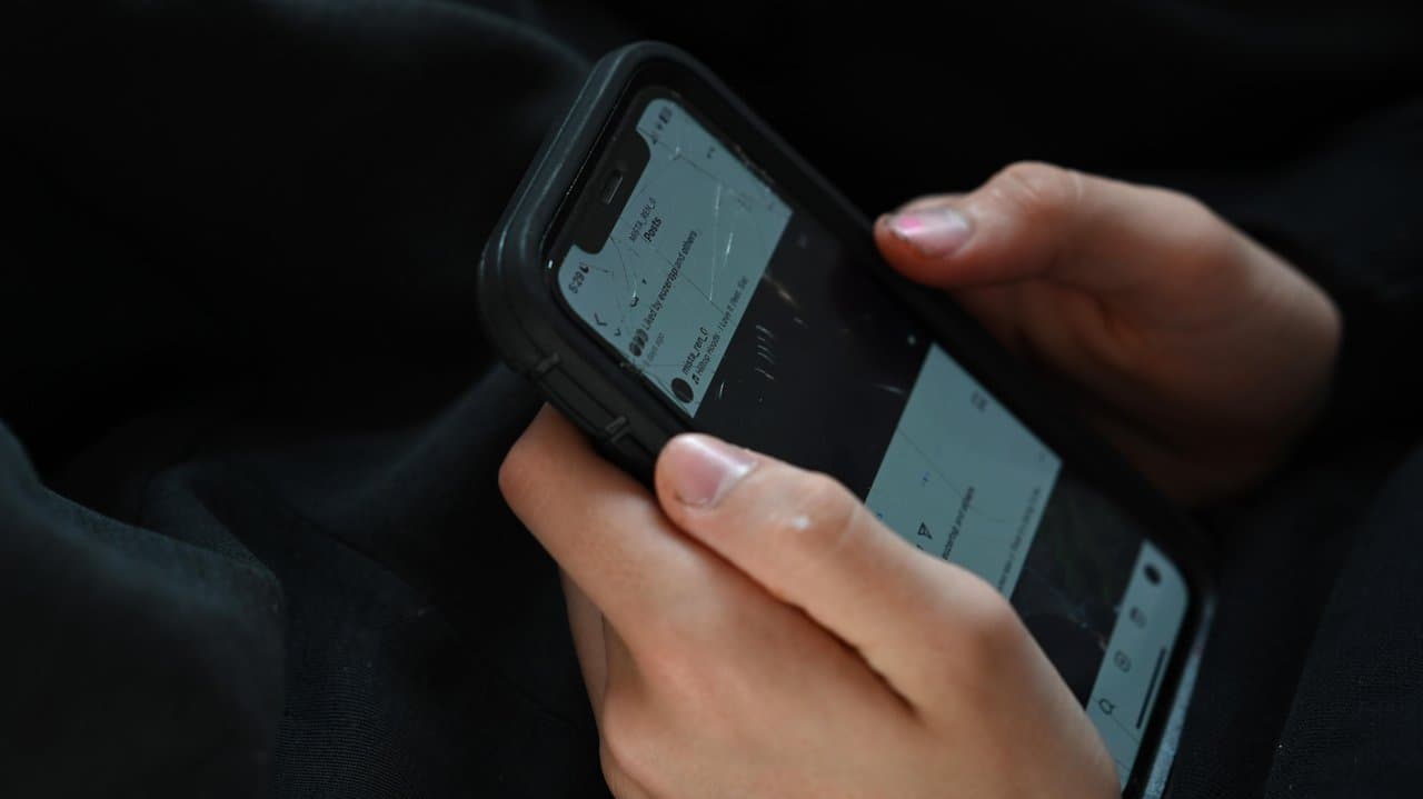 A teenager uses his mobile phone