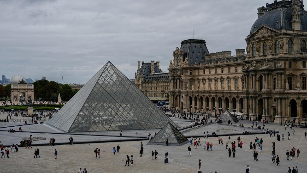 People walk outside the Louvre museum,