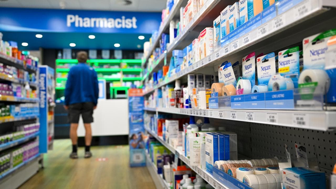 A customer waits at a counter at National Chemist pharmacy