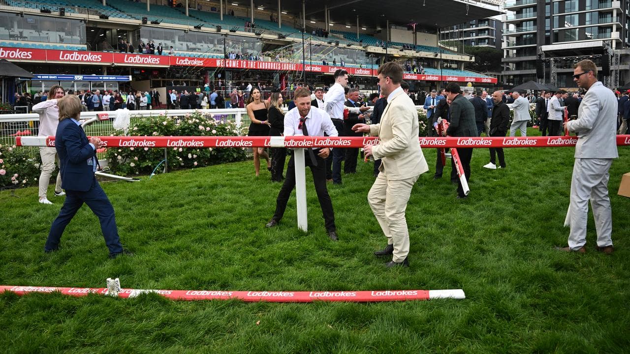 Racegoers dismantle parts of the track