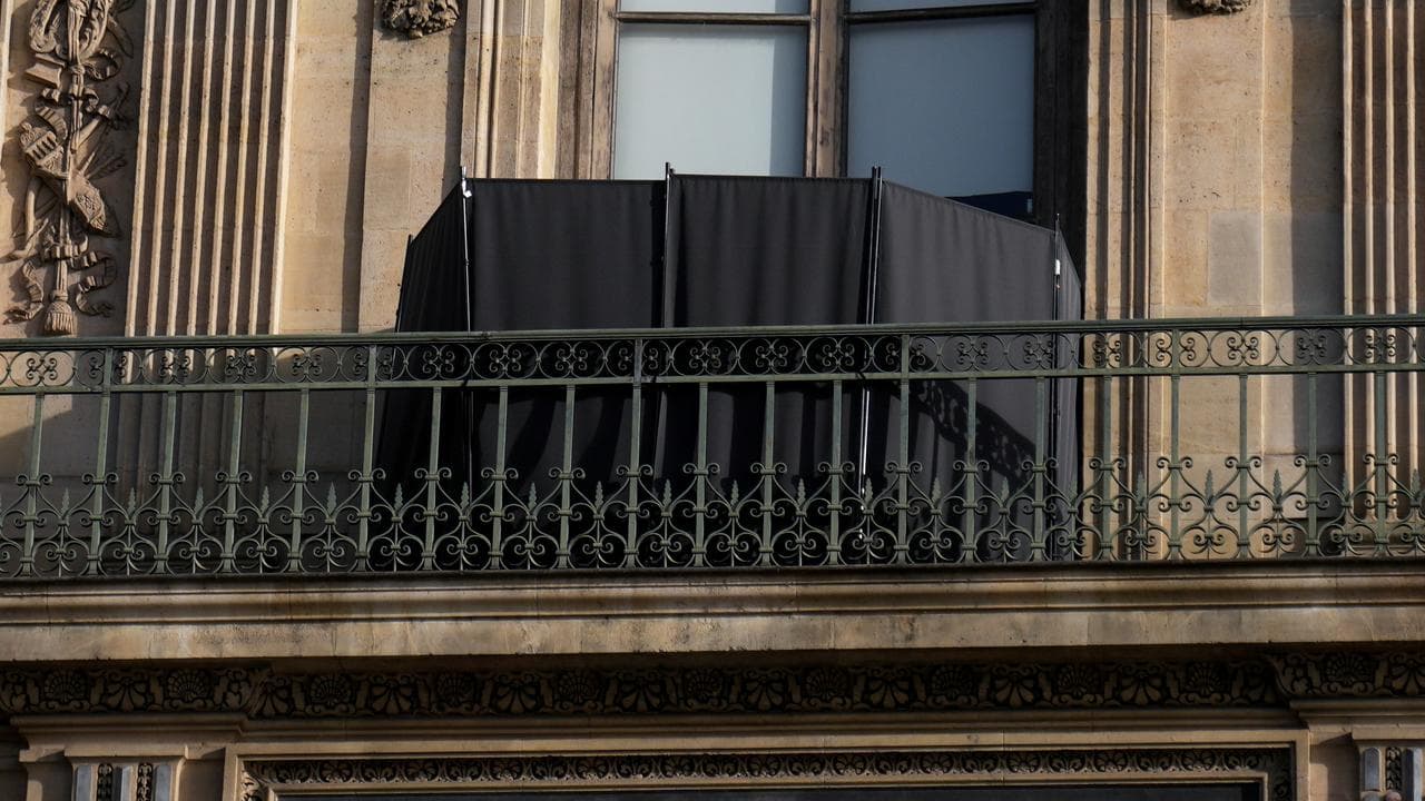 A black curtain hides the window where thieves entered the Louvre