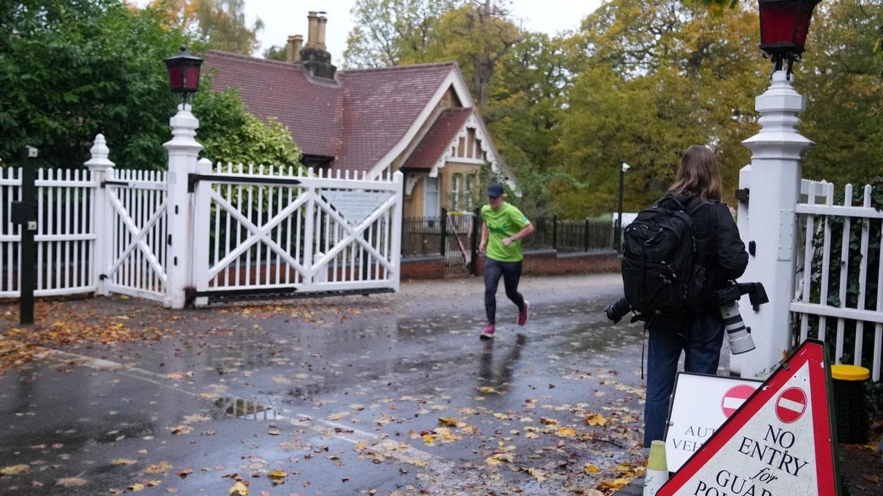 Journalists wait at an entrance near to the Royal Lodge