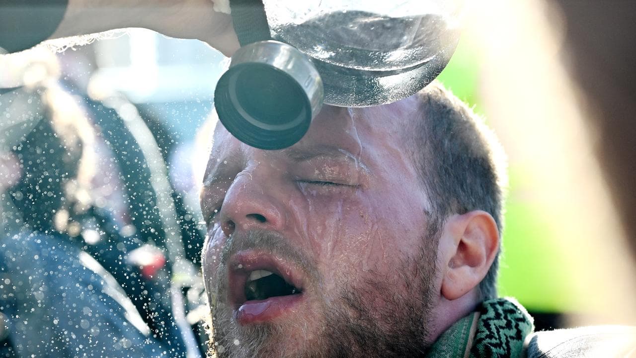 A protester washes his eyes after being pepper sprayed by NSW Police