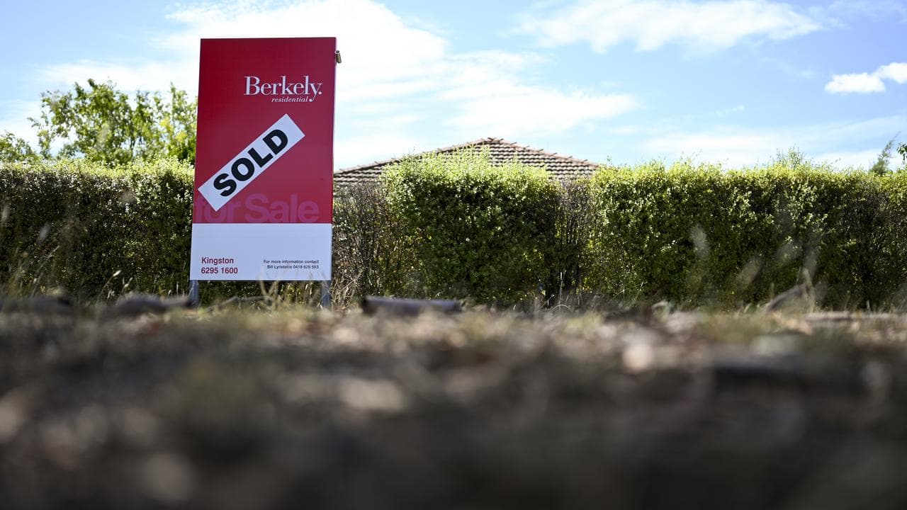 A real estate advertising board next to a house in Canberra