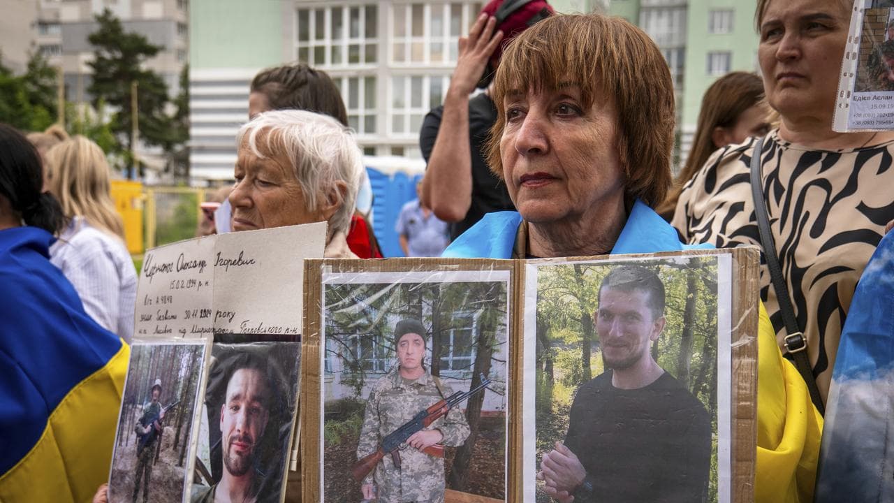 People hold photos of their missing relatives (file image)