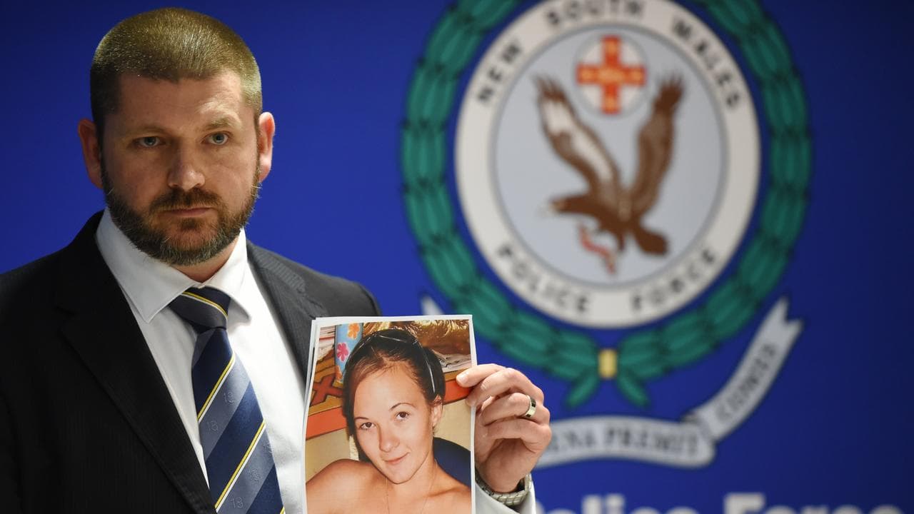 Detective with photo of Karlie Pearce-Stevenson (file)