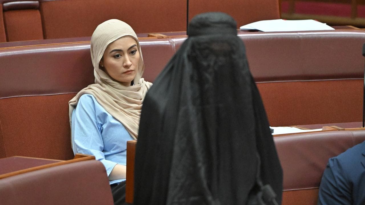 Fatima Payman looks on as Pauline Hanson wears a burqa