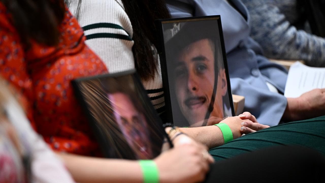 Family hold photos of ADF members who lost their lives to suicide