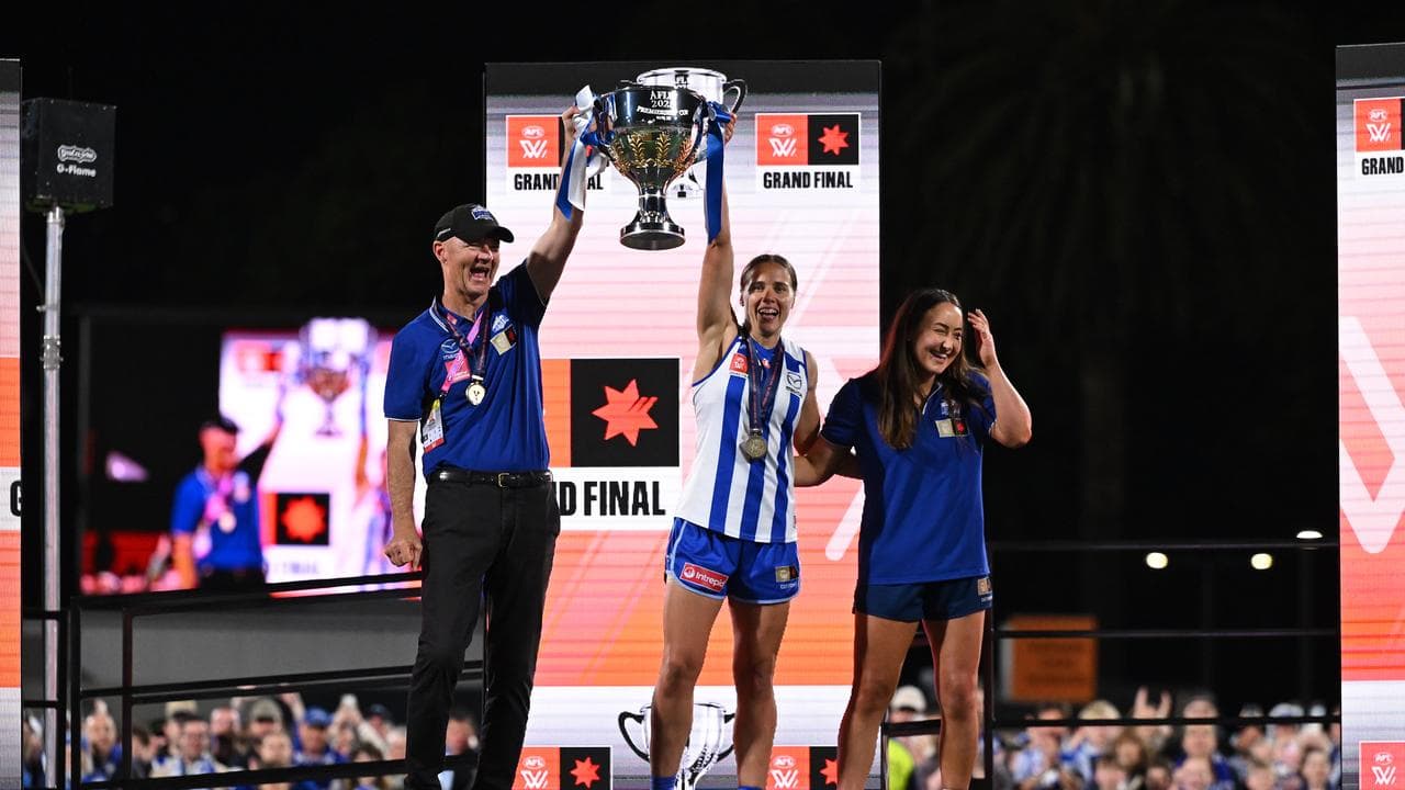 Darren Crocker and captain Jasmine Garner raise the premiership cup.