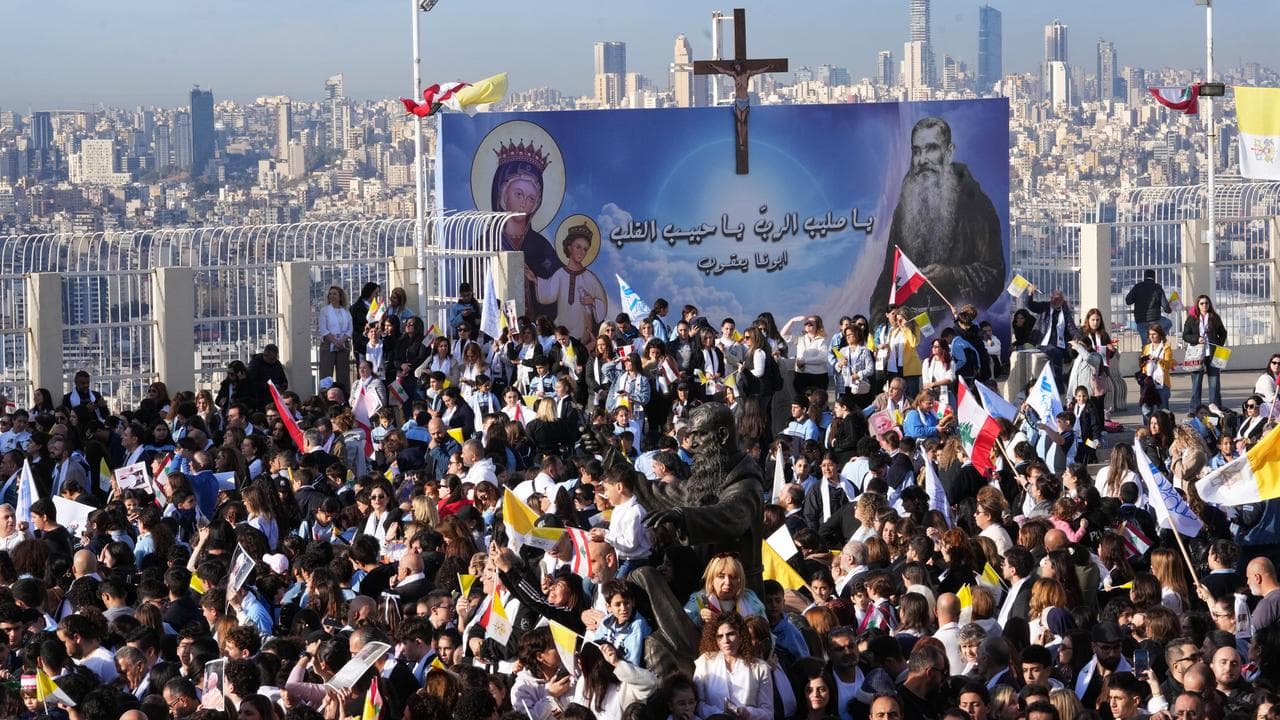 People wait for Pope Leo XIV to visit the De la Croix hospital