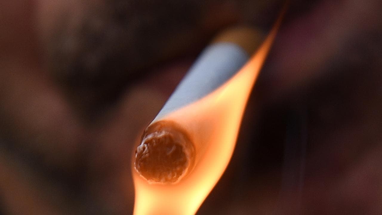 a man pictured lighting a cigarette