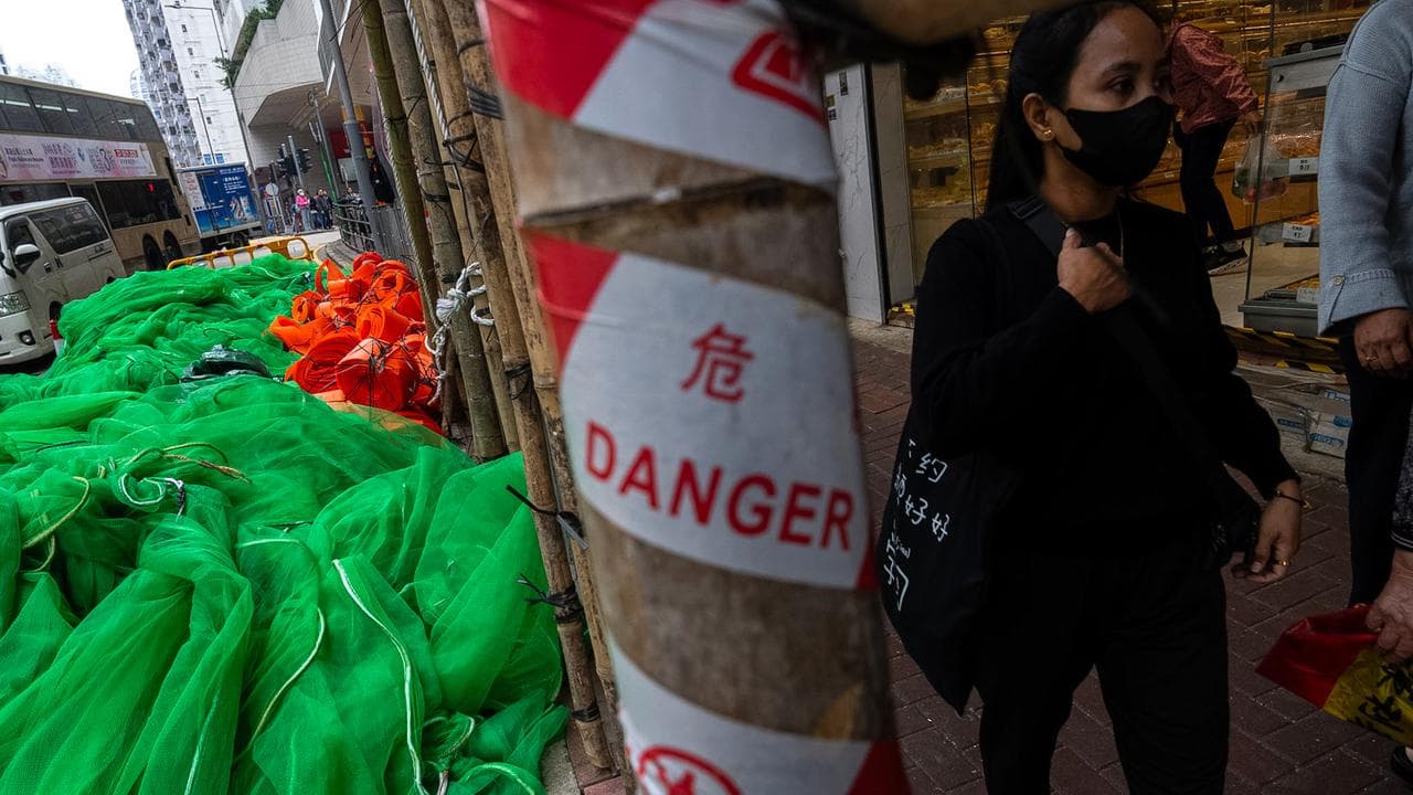 Pedestrians walk past the removed scaffolding nets in Hong Kong