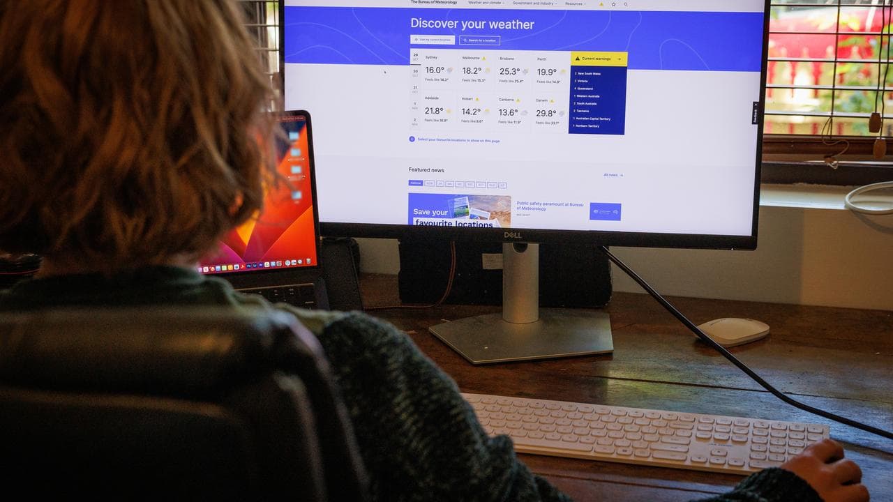 A person uses the BOM weather website on their computer in Melbourne