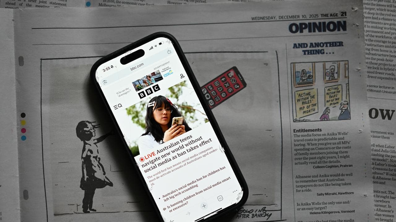 An phone displaying the BBC’s homepage on top of The Age newspaper