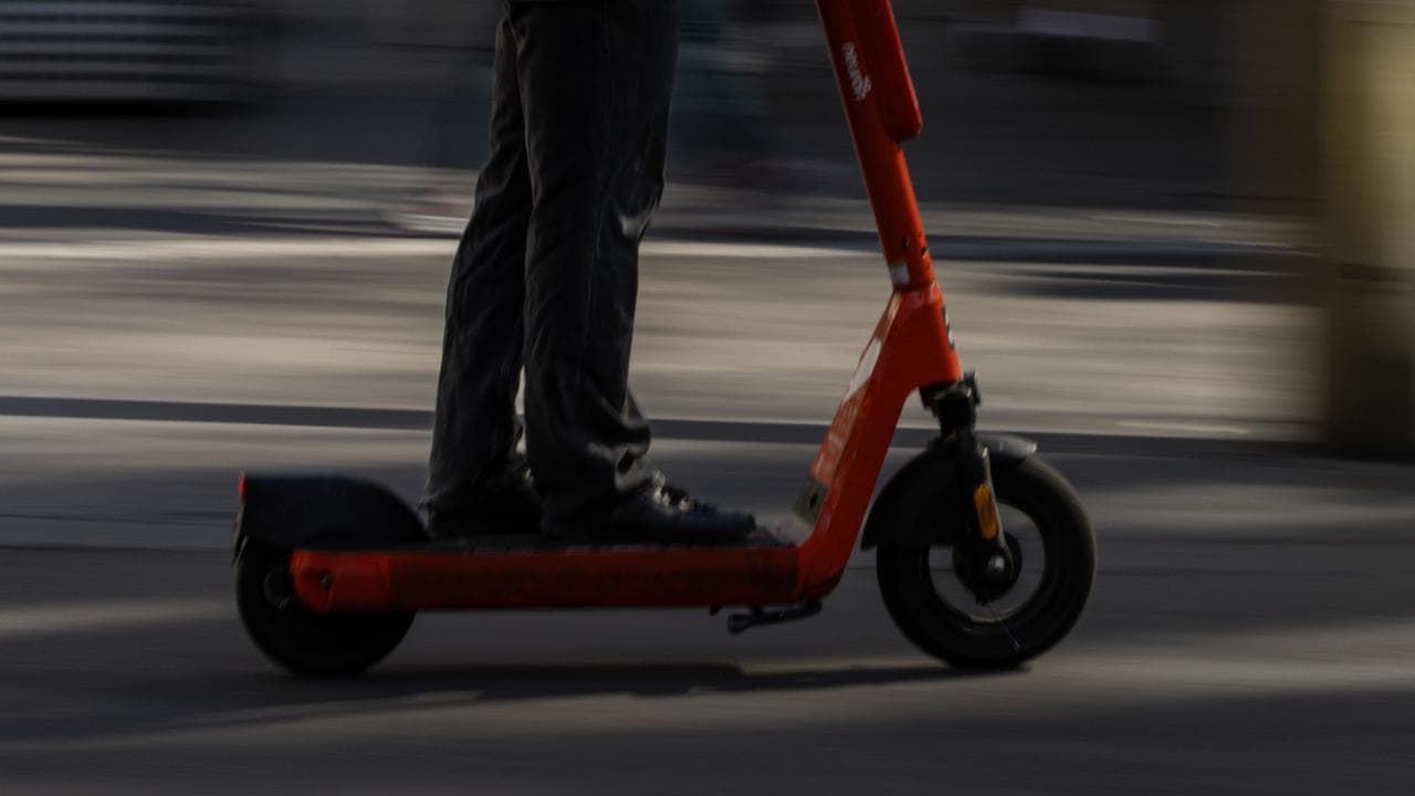 A person is seen riding an electric scooter