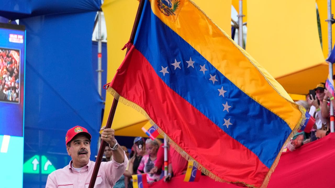 President Nicolas Maduro waves a Venezuelan flag