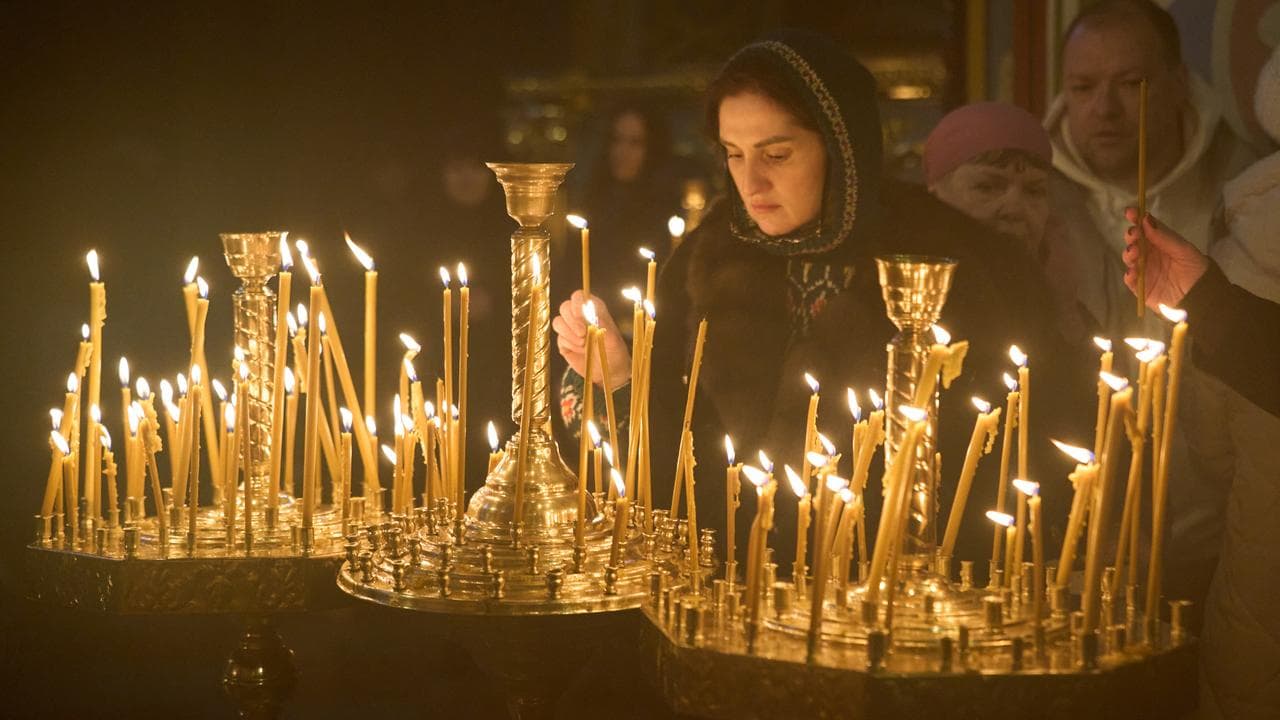 A woman lighting candles in a church in Kyiv