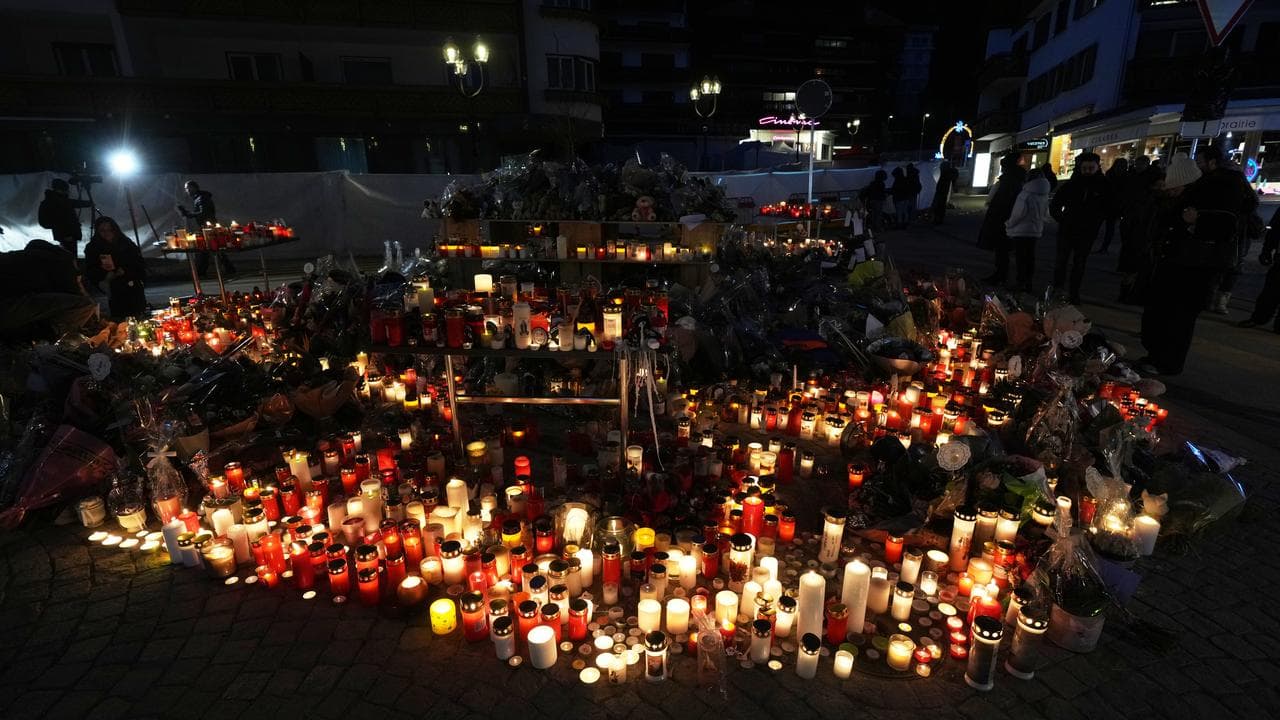 People light candles outside the Le Constellation bar