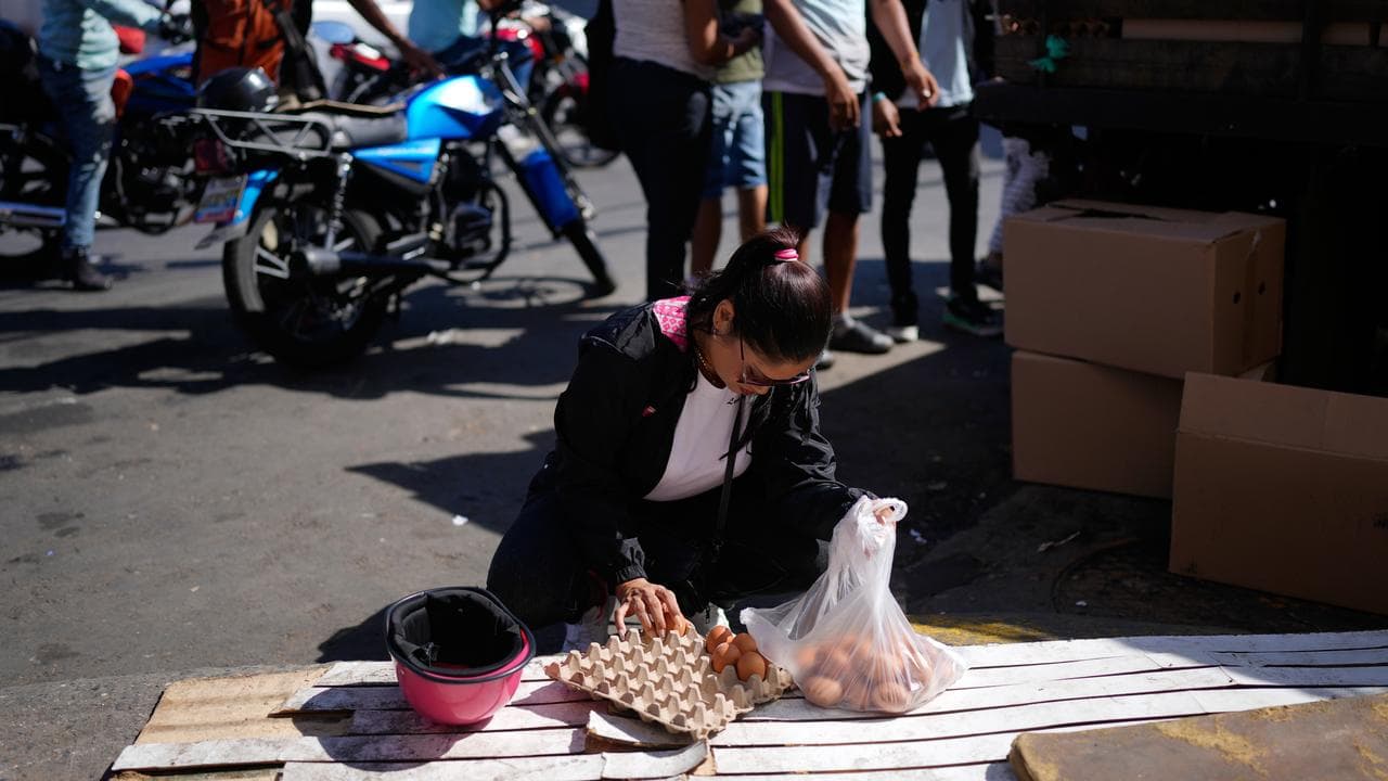 A woman packs eggs she bought at a market in Caracas