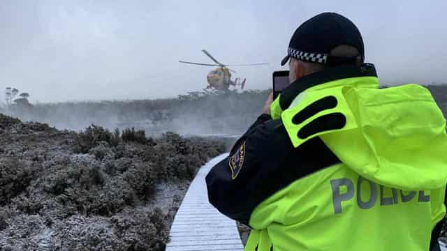 Child among bushwalkers waiting for rescue in snow